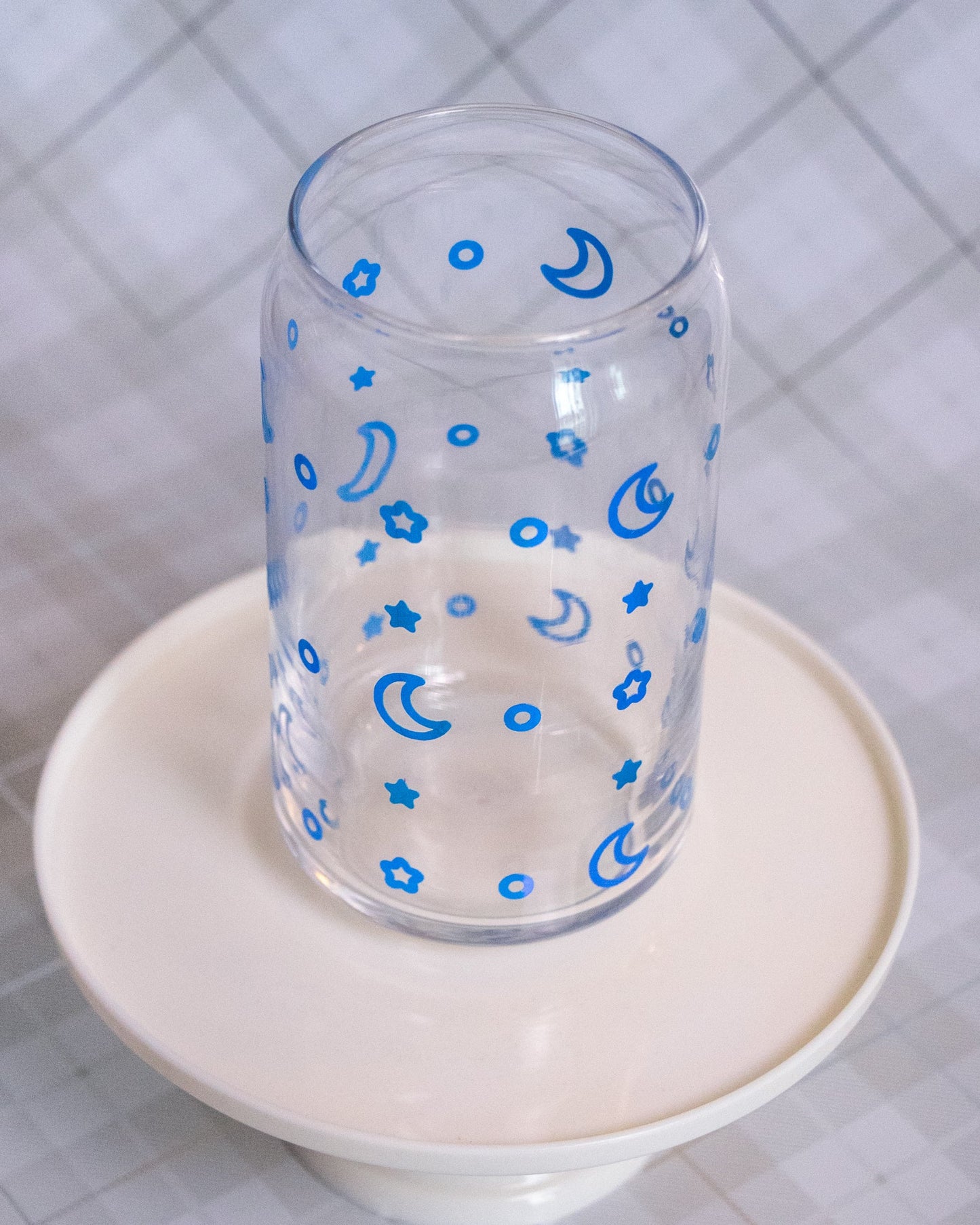 Glass cup with blue vinyl wrap of stars and moons