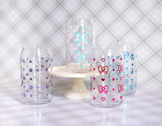 Four glass cups wrapped with vinyl of assorted designs